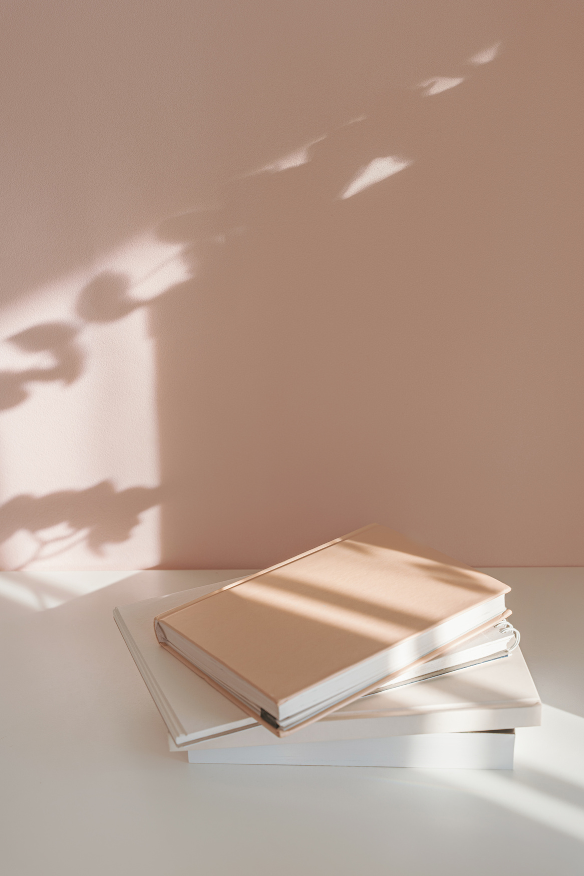 Stack of books and notebooks, minimalist pastel background, studying aesthetic